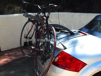 side view of a silver audi tt roadster convertible with a bike rack fitted carrying a bike 