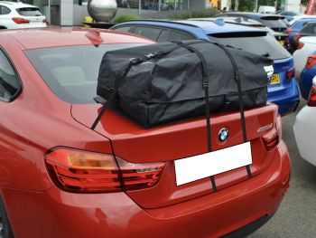 red bmw 4 series 420d coupe with a boot-bag vacation roof box fitted outside north oxford bmw