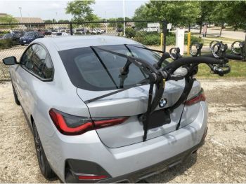 Silver grey bmw 4 series gran coupe g26 parked in a suburban car park photographed from the rear with a bike rack fitted photographed close focusing on the bike rack