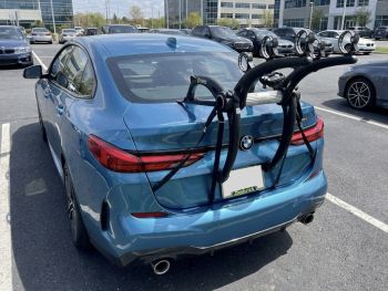 blue bmw 2 series gran coupe 230i F44 in car park with a bike rack fitted to the tailgate photographed close at the rear 