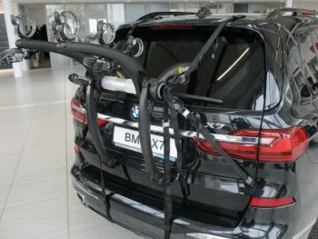black bmw x7 in a bmw showroom with a saris bones ex3 bike rack fitted photogprahed close from the rear focusing on the rack