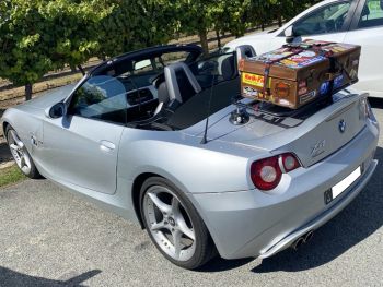 silver bmw z4 e85 with the hd down and a revo-rack black luggage rack fitted carrying a large brown trunk