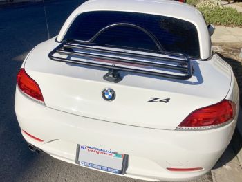White bmw z4 e89 with the roof up and a revo-rack black luggage rack fitted to the trunk photographed close at the rear 