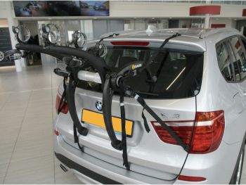 silver bmw x3 with a saris bones ex3 bike rack fitted to then rear photographed close in a bmw showroom 