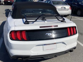 white ford mustang convertible in a car park on a sunny day photographed from the rear with a revo-rack black luggage rack fitted 