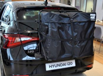 Black Hyundai i20 in hyundai showroom with a hatch-bag roof box alternative fitted to the rear