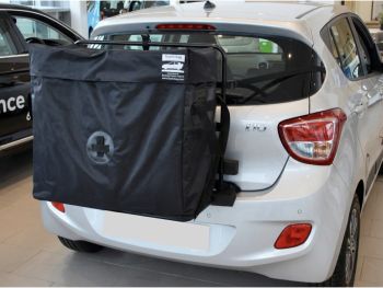 Silver hyundai i10 second generation model in a car showroom with a hatch-bag roof box alternative fitted photographed close at the rear 