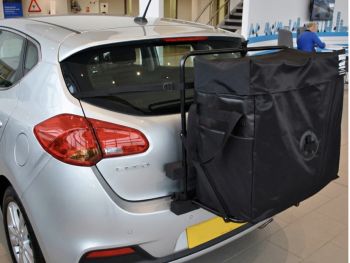 Silver Kia Cee'd JD model second generation in a Kia showroom photographed close at the rear with hatch-bag roof box alternative fitted to the car 