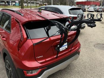 Burgundy kia niro in a car park with a 3 bike rack fitted photogprahed cloise tat the rear focusing on the bike rack
