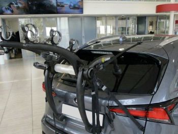 Graphite Lexus AZ10 SUV in a showroom with a 3 bike rack fitted to the tailgate photographed close focusing on the bike rack
