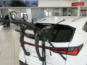 white Lexus NX AZ20 with a 3 bike rack fitted to the tailgate in a used car showroom photographed close at the rear 