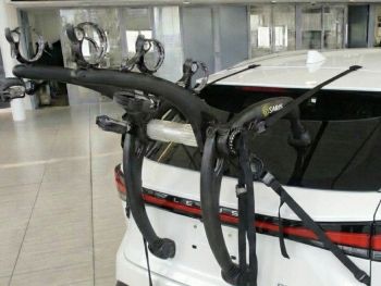 white Lexus RX (ALA10) with a 3 bike rack fitted to the tailgate photographed close at the rear in a car showroom 