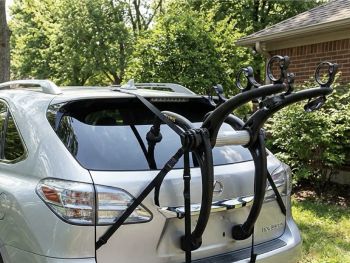 Silver Lexus RX350 3rd Gen next to a garage and bushes on a sunny day with a 3 bike rack fitted 