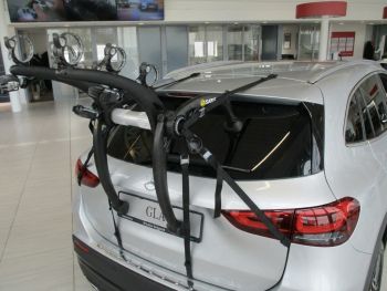silver mercedes benz GLA h247 second generation with a 3 bike rack fitted to the rear photogprahed in a car showroom 