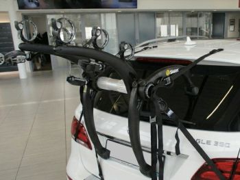 white Mercedes Benz GLE 350 (2015-18) 3rd generation W166/C292 with a 3 bike rack fitted tot he rear photogprahed close in a showroom 