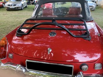 red mgb in a car park under a tree with a revo-rack luggage rack fitted photographed close at the rear 