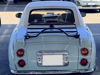 pastel blue nissan figaro with a revo-rack black luggage rack fitted photographed close at the rear from the rear