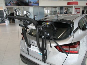 Silver Nissan juke with a 3 bike rack attached photogprahed in a Nissan Showroom