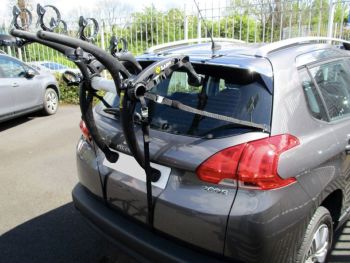 grey graphite peugeot 2008 with a 3 bike rack fitted photogprahed in car park from the rear on a sunny day