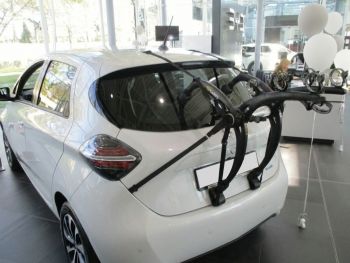 white renault zoe in a car showroom with a bike rack fitted next to some balloons photographed close at the rear focusing on the bike rack 