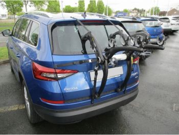 blue skoda kodiaq 2017 2023 model with a bike rack fitted to the tailgate photographed close from the rear outside a skoda garage focusing on the bike rack
