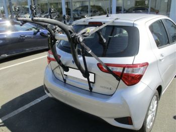 Silver Toyota Yaris 2012 to 2021 model with a bike rack fitted photographed close from the rear outside a toyota garage focusing on the bike rack