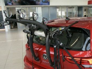 VW Volkswagen Golf Mk8 in red in a showroom with a 3bike rack fitted to the rear photographed close up on the bike rack