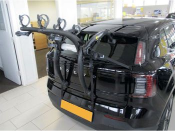 Black Volvo EX 30 in a volvo showroom with a 3 bike rack fitted to the rear photographed close focusing on the bike rack 