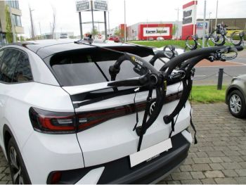 White VW Volkswagen ID5 outside a VW garage with a bike rack fitted photographed close from the rear focusing on the bike rack