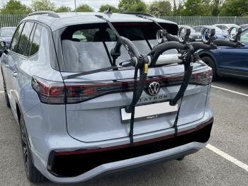 Grey VW Tayron in a car park with a bike rack fitted to the tailgate photographed close at the rear focusing on the bike rack