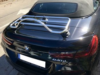 Black BMW 8 series convertible on a road with a revo-rack chrome luggage rack fitted photographed from the rear 