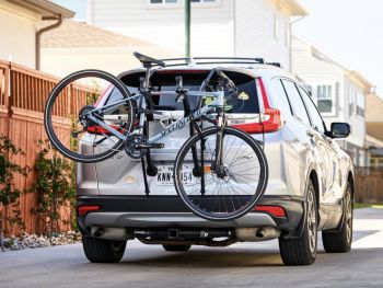 silver honda cr-v photographed from the rear with a 3 bike rack fitted carrying a bike