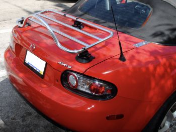 red mazda miata mx5 nc with a revo-rack pa luggage rack fitted to the trunk photographed close at the rear