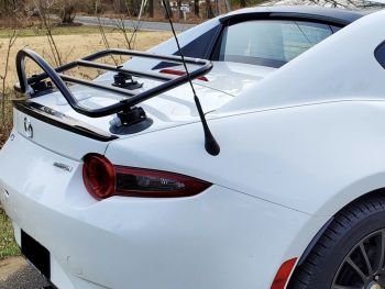 close up of a white mazda miata mx5 rf with a black lip spoiler on the trunk and a revo-rack black luggage rack fitted 
