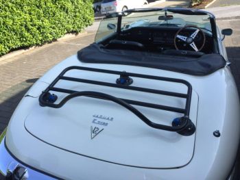 White jaguar e type convertible with a luggage rack fitted on a sunny day