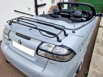 Grey silver saab 93 convertible on a drive outside a house with the roof down and black luggage rack fitted 